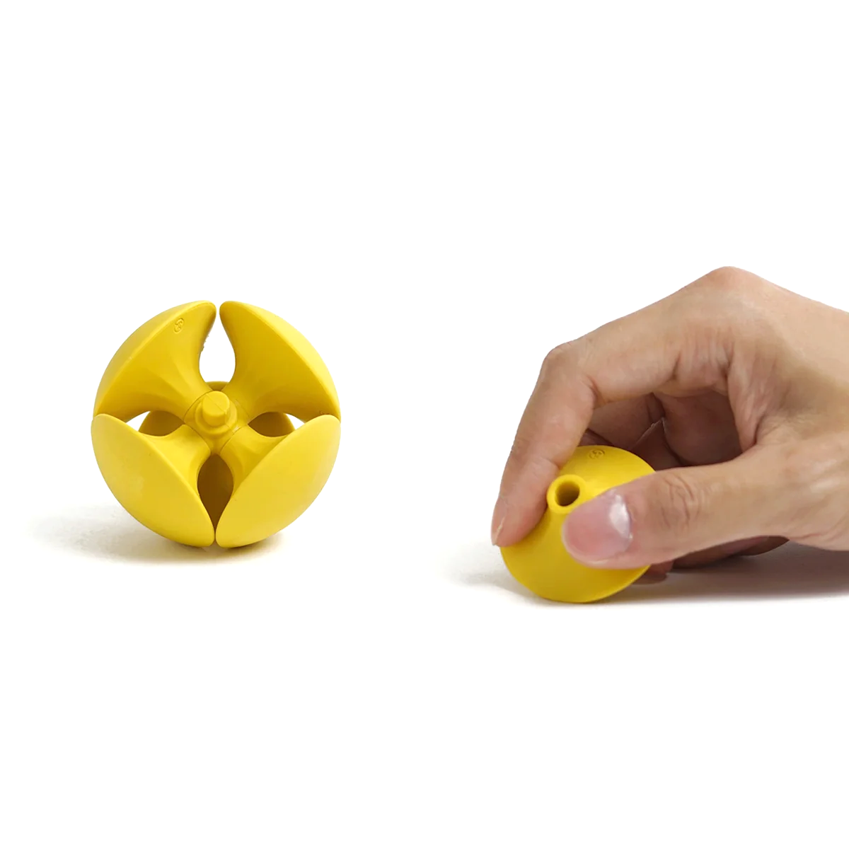 HMM Eraser Ball in Sunshine Yellow als Kartenhalter – eine Hand steckt eine Visitenkarte zwischen die gelben Radiergummi-Elemente.