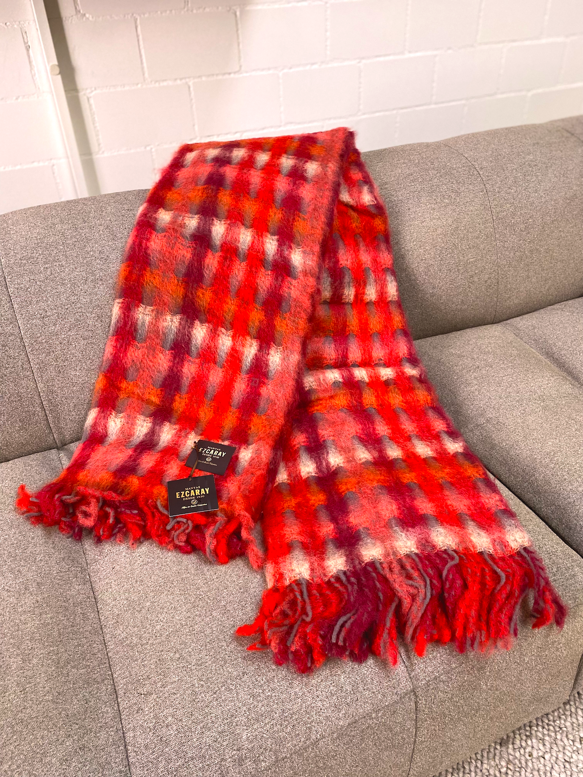 MANTAS EZCARAY Mia MI-54 Mohair-Wolldecke mit flauschigem Karomuster in Rot, Rosa, Bordeaux und Kreideweiss, dekorativen Fransen in Rot und Grau.
